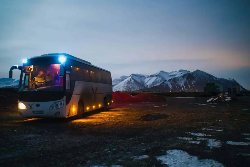 white and black bus running near the mountain
