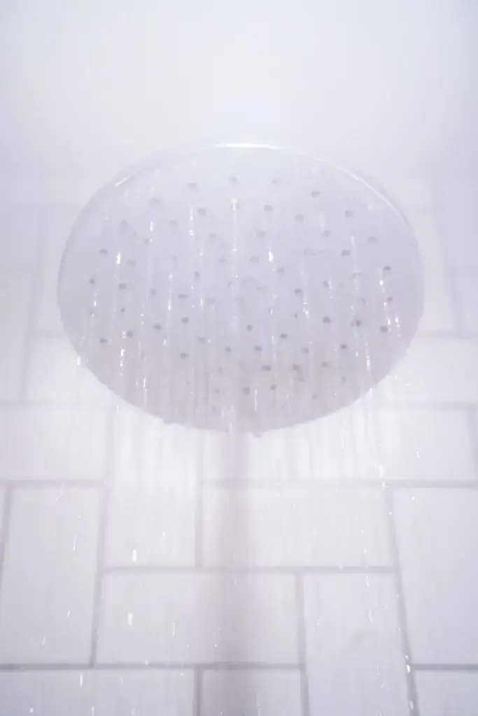 water from round gray stainless steel shower head