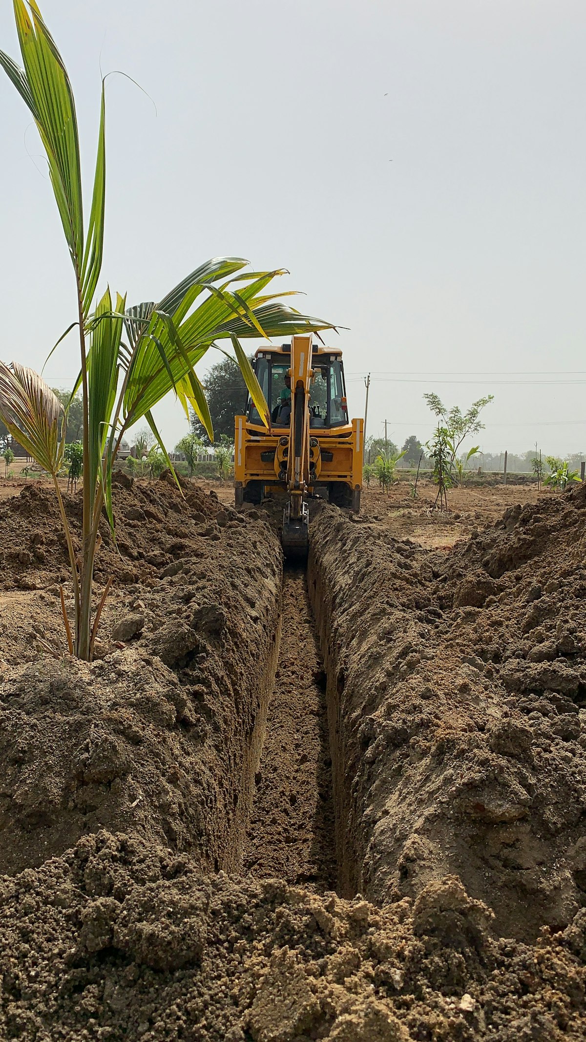 A digger cutting a trench for underground pipes